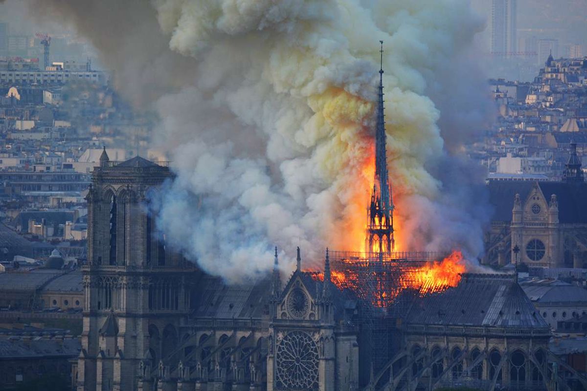 Api membakar bagian atas Gereja Notre Dame di Paris, Perancis, pada Senin (15/4/2019). Belum diketahui penyebab pasti kebakaran itu, api dengan cepat melalap atap dan puncak menara gereja bernuansa Gotik yang dibangun pada abad ke-12 itu.