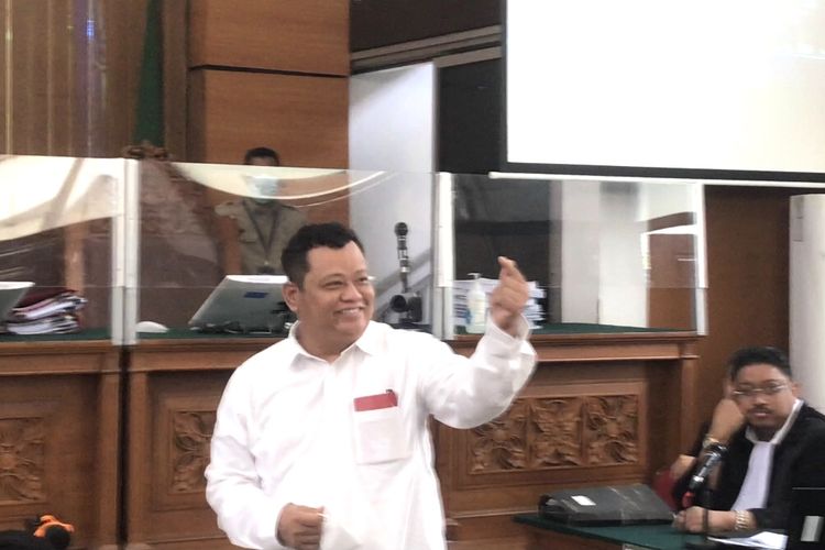 Terdakwa kasus pembunuhan berencana terhadap Nofriansyah Yosua Hutabarat atau Brigadir J, Kuat Ma'ruf menyapa pengunjung sidang dengan simbol love dua jari ala Korea atau finger heart saat memasuki ruang sidang utama Pengadilan Negeri (PN) Jakarta Selatan, Senin (5/12/2022) pagi.