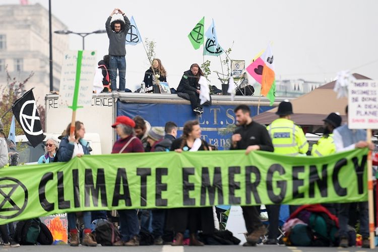 Para aktivis memegang spanduk dalam unjuk rasa soal perubahan iklim dengan memblokir jalan di Jembatan Waterloo pada hari kedua di London, Inggris, Selasa  (16/4/2019). (AFP/DANIEL LEAL-OLIVAS)