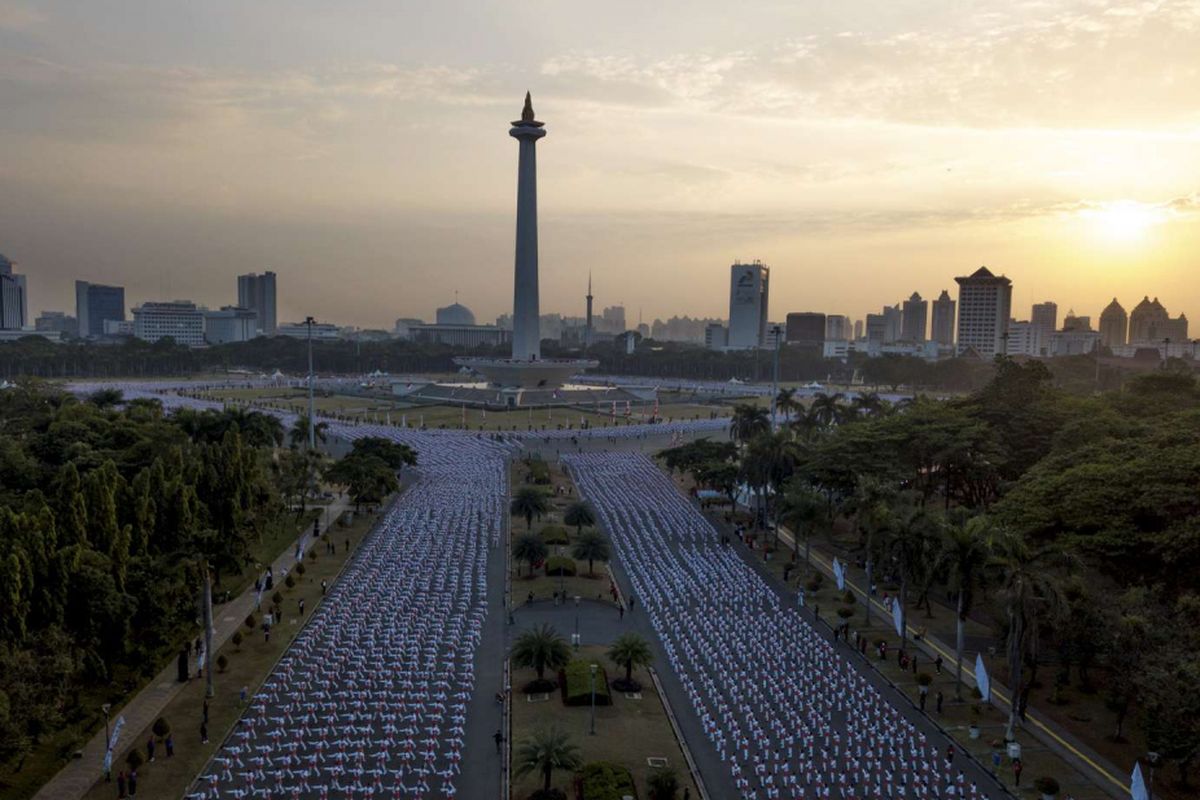 Ribuan warga melakukan senam poco-poco saat pemecahan rekor dunia senam massal poco-poco di Monas, Jakarta, Minggu (5/8/2018). Kegiatan dalam rangka menyambut Asian Games 2018 itu diikuti 65 ribu peserta dari berbagai kalangan.