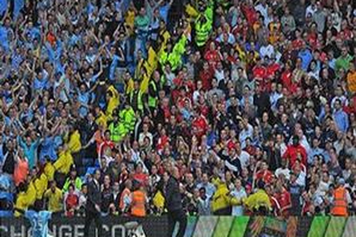 Penyerang Manchester City, Emmanuel Adebayor (kiri) merayakan golnya di depan pendukung Arsenal saat kedua kubu bertanding di City of Manchester, Sabtu (12/9).