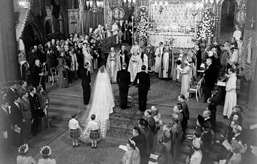 The scene at the altar steps during the Royal Wedding Ceremony in Westminster Abbey. H.M the King stands to the left of the bride; on the bridegroom's right is the groomsman, the Marques of Milford Haven. The bride's train is held by two pages T.R.H Prince William of Gloucester and Prince Michael of Kent.