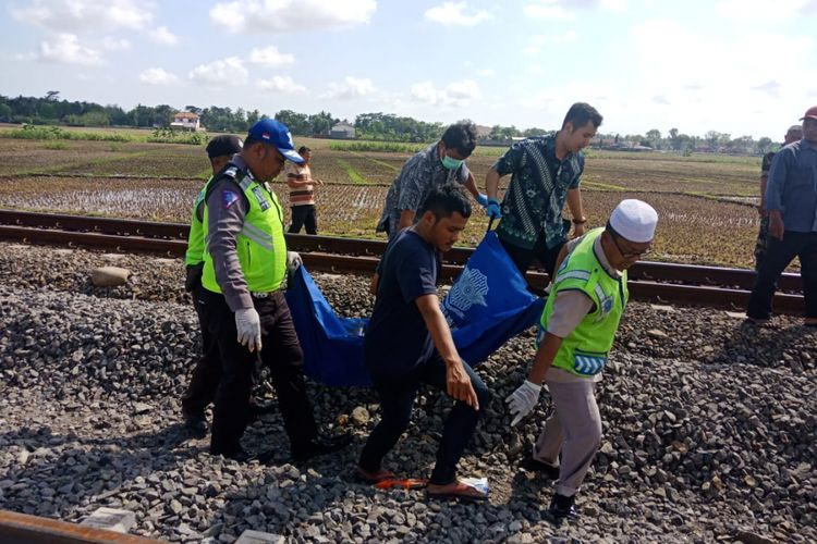 Petugas mengevakuasi jasad Arif Amaludin (24) warga warga Desa Sidoagung, Kecamatan Sruweng, Kebuman, Jawa Tengah yag meregang nyawa setelah tersambar Kereta Api Joglokerto jurusan Purwokerto-Solo, Jumat (16/11/2018).