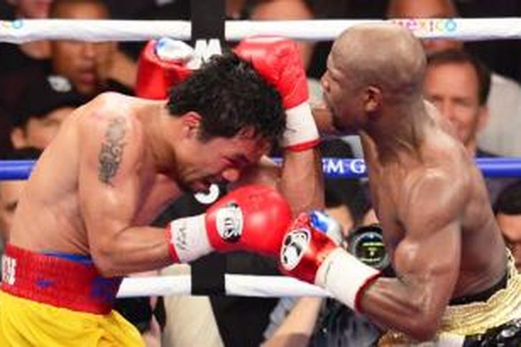 Floyd Mayweather Jr. (kanan) dan Manny Pacquiao (kiri) saling pukul saat tarung di MGM Grand Garden Arena in Las Vegas, Nevada, Sabtu (2/5/2015) malam atau Minggu pagi WIB.