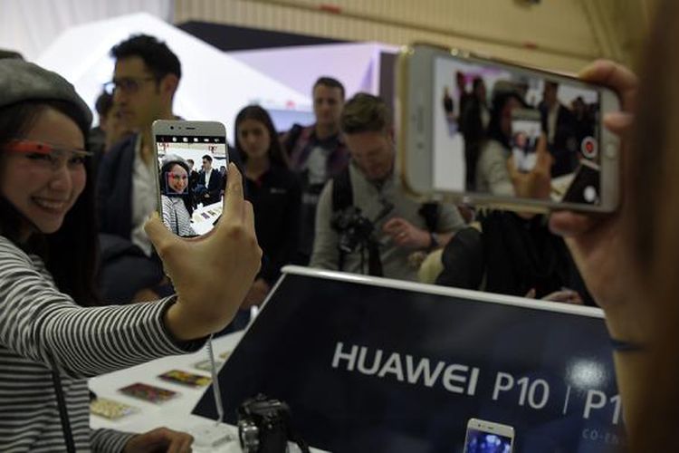 Wartawan menjajal model anyar besutan perusahaan telekomunikasi asal China, ponsel Huawei P10, pada malam menjelang pembukaan ajang Mobile World Congress di Barcelona, Spanyol, Minggu (26/2/2017).