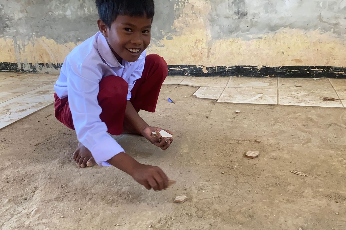 Salah seorang siswa kelas V SDN Ciaripin, berinisiatif mengumpulkan pecahan keramik karena khawatir terinjak orang lain. Rabu (21/8/2024).