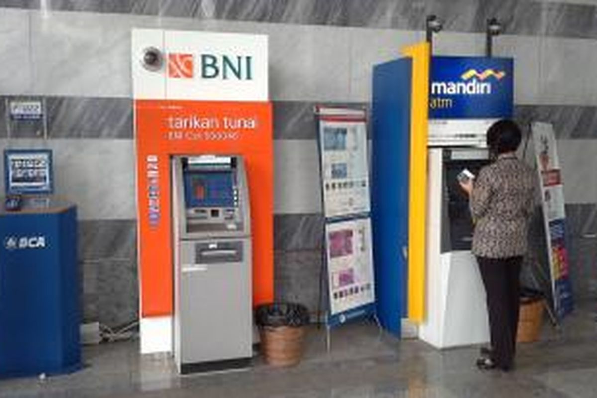 Nasabah melakukan transaksi dengan mesin ATM.