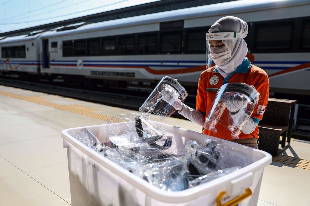 Petugas merapikan pelindung wajah di Stasiun Pasar Senen, Jakarta Pusat, Jumat (12/6/2020). Kereta Api Jarak Jauh Reguler kembali beroperasi dan ada satu kereta yang diberangkatkan yakni dari Stasiun Pasar Senen menuju Stasiun Purwokerto di Jawa Tengah, pengoperasian diikuti dengan penerapan protokol pencegahan COVID-19.