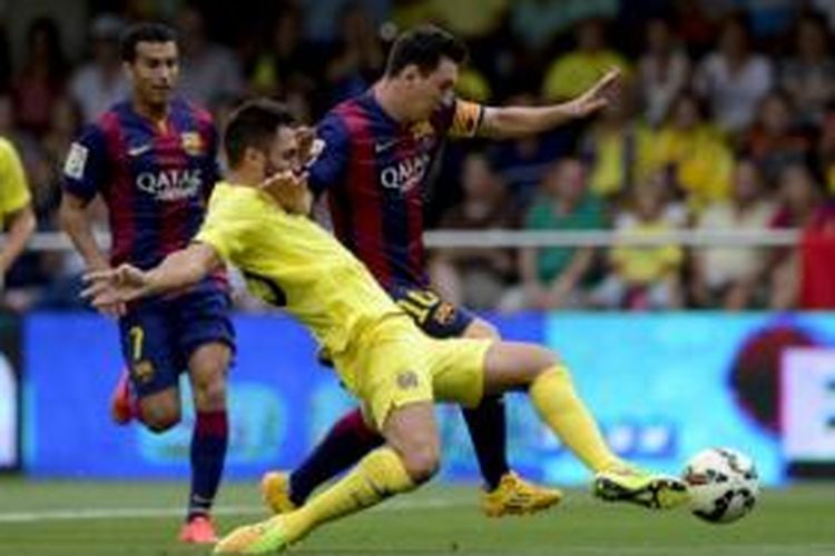 Striker Barcelona, Lionel Messi, mencoba melewati hadangan bek Villarreal, Victor Ruiz, pada laga Primera Division di Stadion El Madrigal, Villarreal, Minggu (31/8/2014).