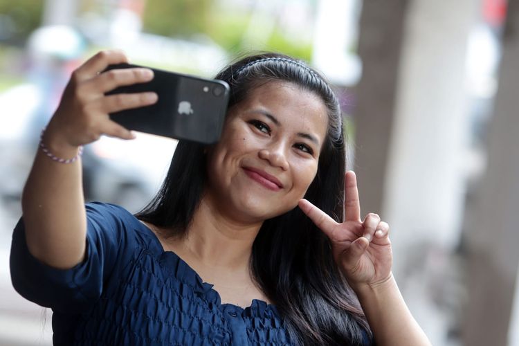 Putri seorang warga Surabaya saat selfie menggunakan iphone.