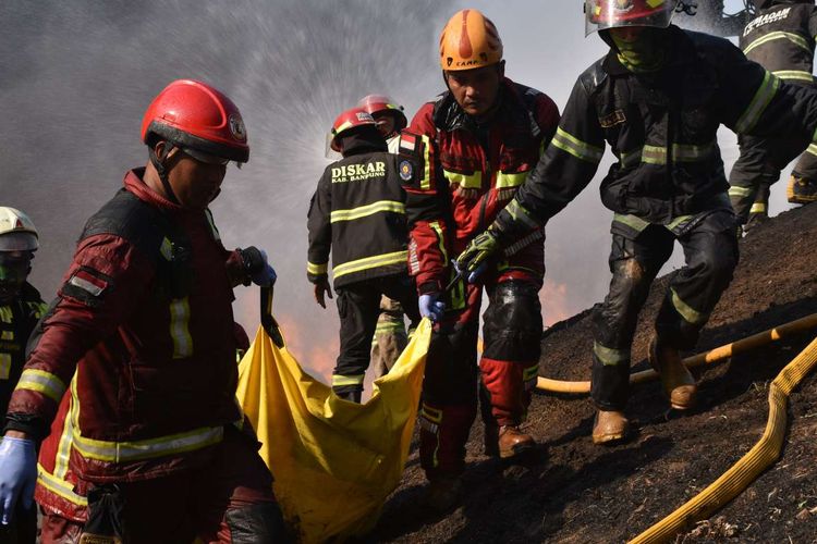 Petugas tengah mengevakuasi korban meninggal dalam kebakaran pipa minyak pertamina di Jalur KCIC tepatnya di kilometer 130, Kampung Mancong, Kelurahan Melong, Cimahi Selatan, Jawa barat, Selasa (22/10/2019).