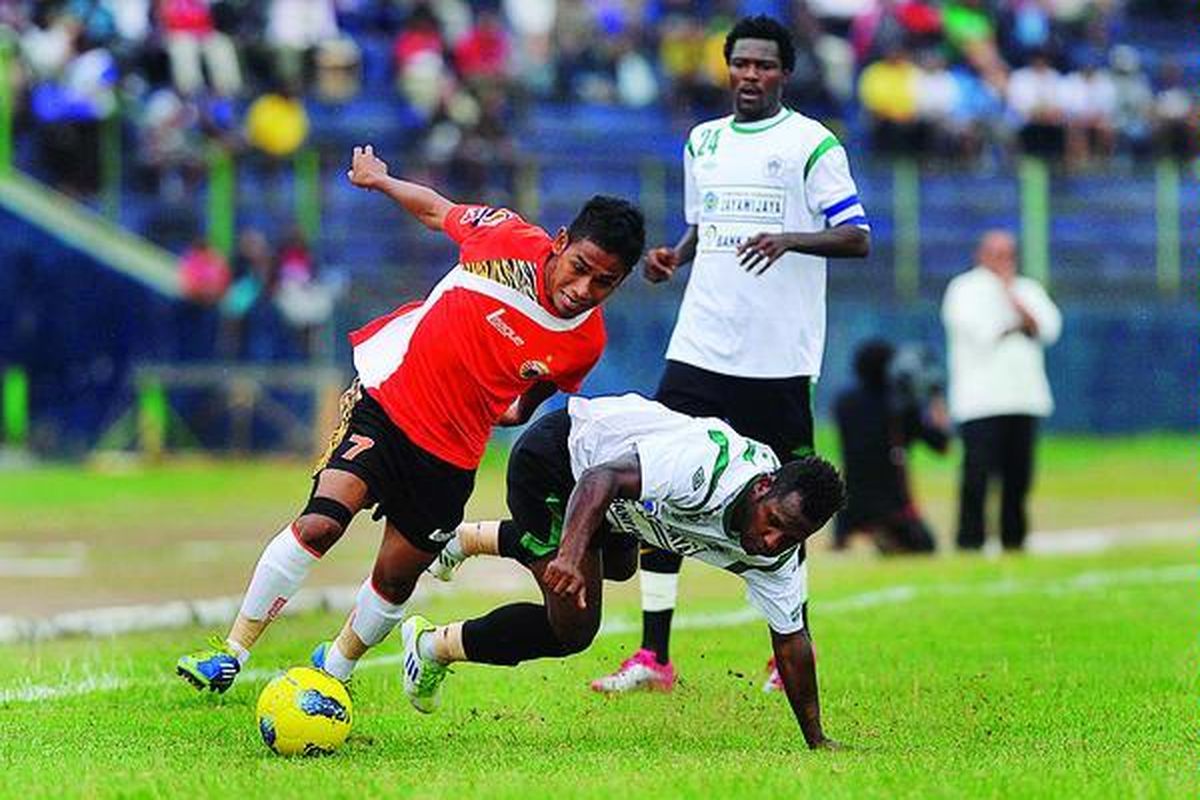 Ramdani Lestaluhu (kiri), pemain Persija Jakarta, berebut bola dengan Isak Konon, pemain Persiwa Wamena, dalam pertandingan Liga Super  Indonesia  di Stadion Mandala Krida, Yogyakarta, Jumat (3/2). 