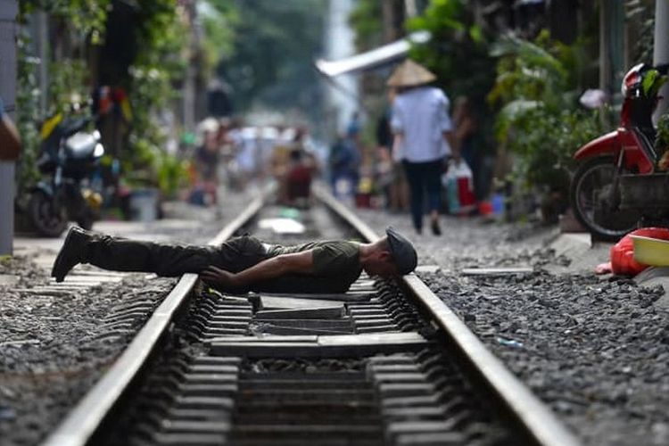 Turis berfoto di rel kereta Old Quarter, Vietnam. 