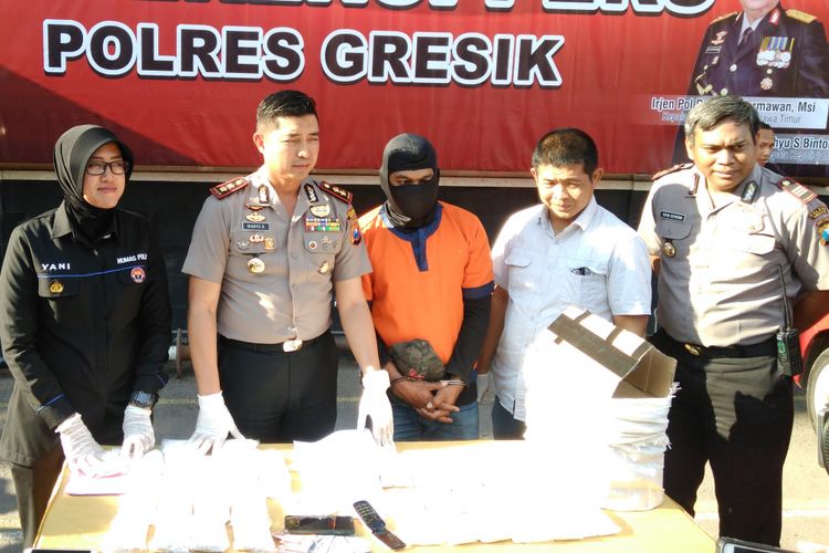 Tersangka HS (tengah) dihadirkan dalam rilis di halaman Mapolres Gresik, Kamis (13/9/2018).