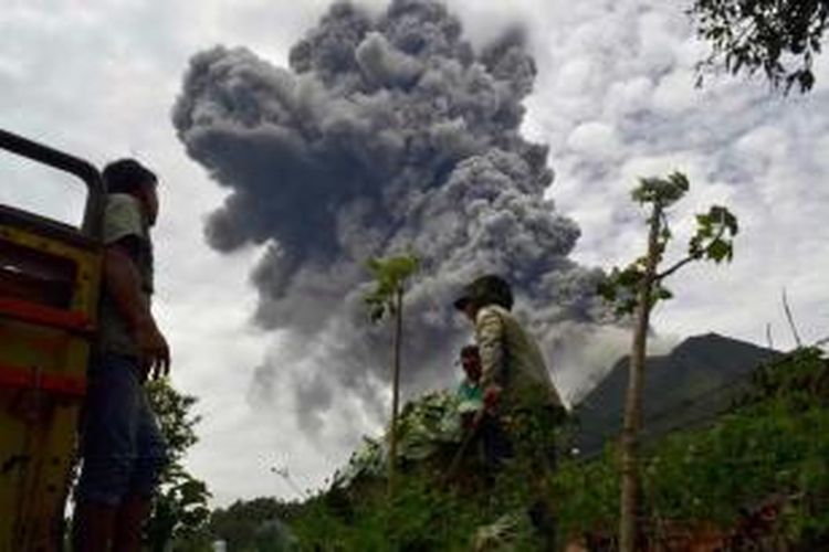 Petani terburu-buru membawa hasil panen mereka ketika Gunung Sinabung di Kabupaten Karo, Sumut, meletus lagi Selasa, 17 September 2013 pukul 12.03. Status gunung Siaga III.