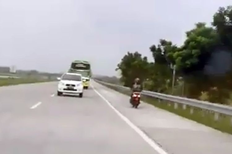 Tangkapan layar dari video seorang pengendara motor yang melaju di jalan tol Jombang - Mojokerto, Jawa Timur, pada Kamis (26/12/2019).