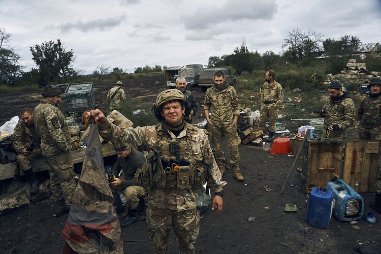 Seorang tentara Ukraina mengangkat bendera Rusia untuk berdemonstrasi di Izium, wilayah Kharkiv, Ukraina, Selasa, 13 September 2022.