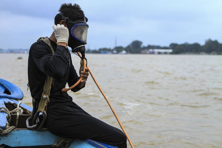 Penyelam untuk berburu harta karun di Sungai Musi, Palembang bersiap memulai pencarian.