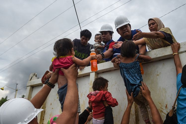Tim penyelamat membantu anak-anak naik ke sebuah truk setelah diselamatkan dari rumah mereka di sebuah desa di pinggiran Marawi, Filipina, Rabu (31/5/2017). Pertempuran berdarah terjadi antara militer Filipina dengan pasukan Maute di Marawi dalam upaya menangkap pemimpin kelompok Abu Sayyaf, Isnilon Hapilon.
