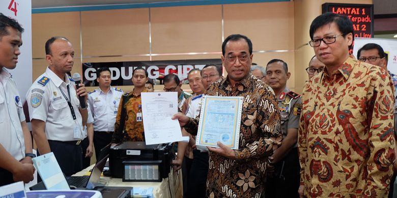 Menteri Perhubungan Budi Karya Sumadi didampingi Ketua AISI Johanes Loman menunjukkan perbedaan SRUT dan E-SRUT