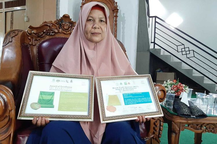 Budiana (51), satu di antara penenun kain songket Sambas, menunjukkan dua piagam penghargaan yang pernah diraihnya.