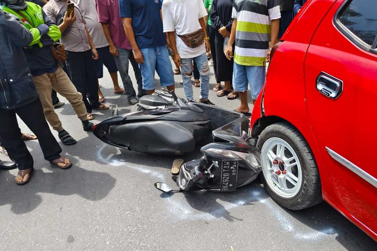 Sepeda motor yang dikendarai korban terhimpit di mobil yang sedang terparkir di sisi kiri jalan, dalam kecelakaan lalu lintas di Jalan Sangnaualuh, Kota Pematang Siantar, Sumatera Utara, Rabu (17/7/2024). 