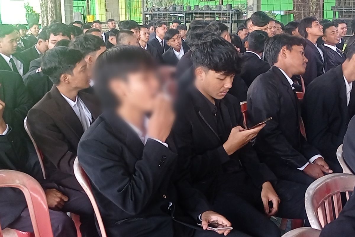 Salah satu siswa SMK di Magetan asyik merokok diantara ratusan siswa lainnya saat menunggu diwisuda di acara kelulusan siswa. Mereka mengaku nekat merokok karena tak lagi mengenakan seragam sekolah.