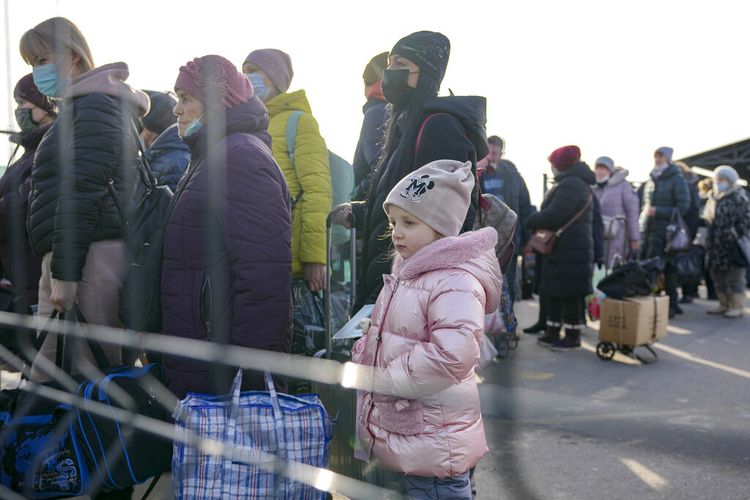 Seorang gadis kecil menunggu bersama dengan orang-orang yang menyeberang ke wilayah yang dikuasai pemerintah Ukraina dari wilayah yang dikuasai separatis pro-Rusia di Stanytsia Luhanska, satu-satunya titik penyeberangan yang buka setiap hari, di wilayah Luhansk, Ukraina timur, Selasa, 22 Februari 2022. 