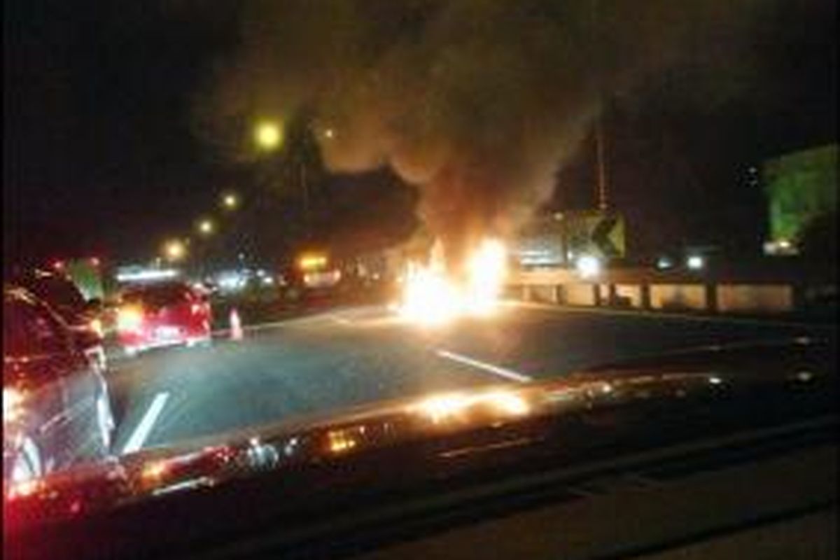 Sebuah mobil Honda Mobilio B 1438 FOD terbakar di KM 4 Tol Pondok Gede Barat arah ke Bekasi, Jumat (3/10/2014) malam. 