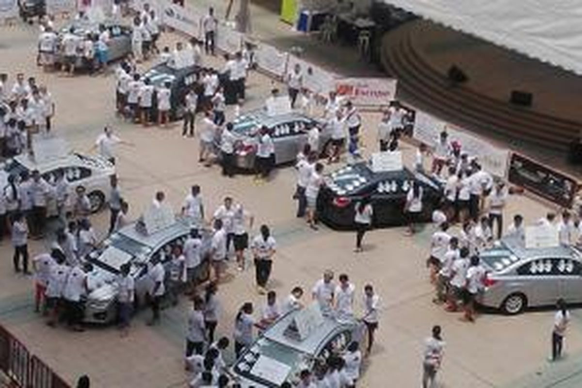 Peserta kontes MediaCorp Subaru Challange 2014 mulai melakukan tantangan daya tahan memegang mobil, di Civic Plaza, Ngee Ann City, Singapura, Sabtu (8/11/2014).