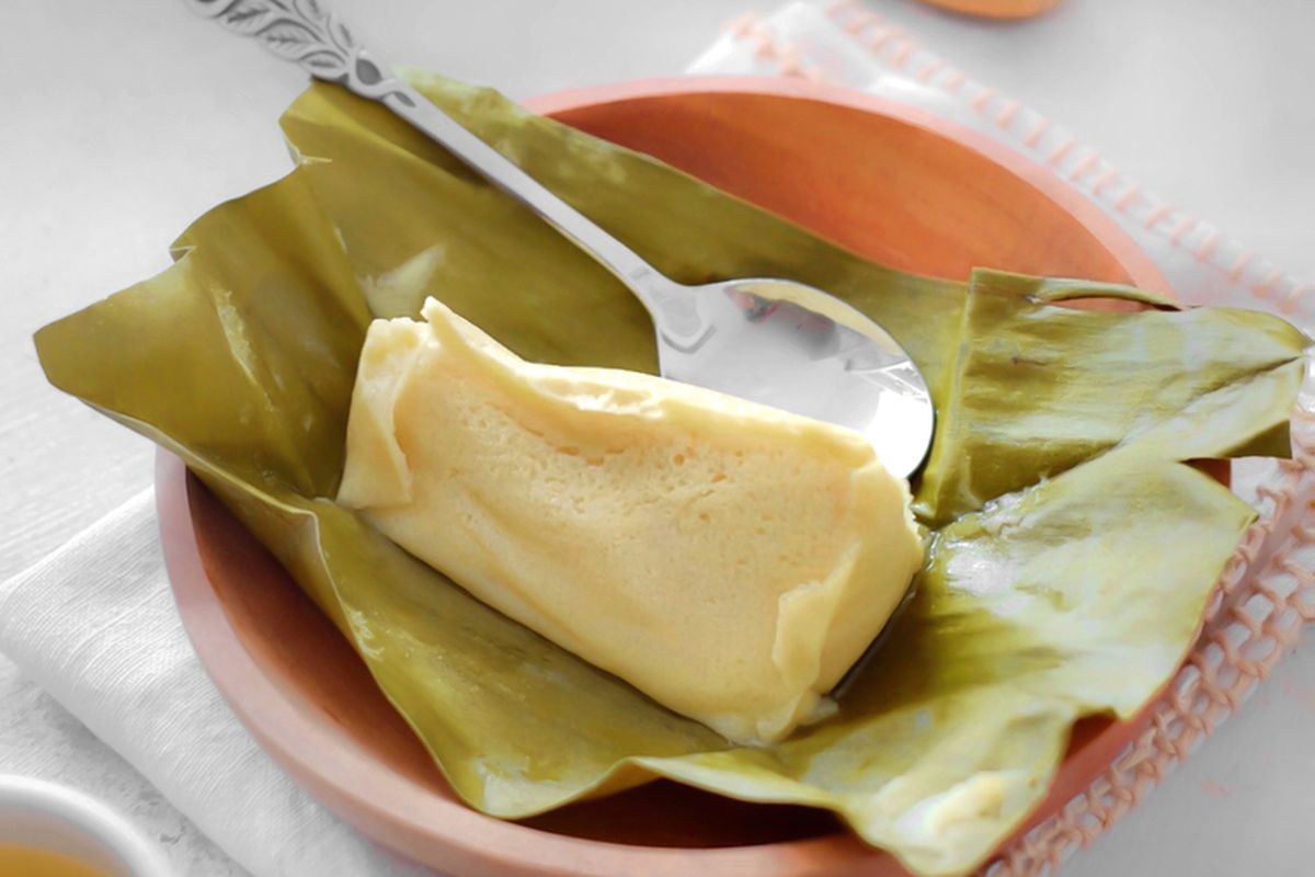 Seporsi Barongko Pisang khas Bugis, tersaji dalam bungkus daun pisang dengan tekstur lembut dan warna kuning keemasan yang menggoda selera