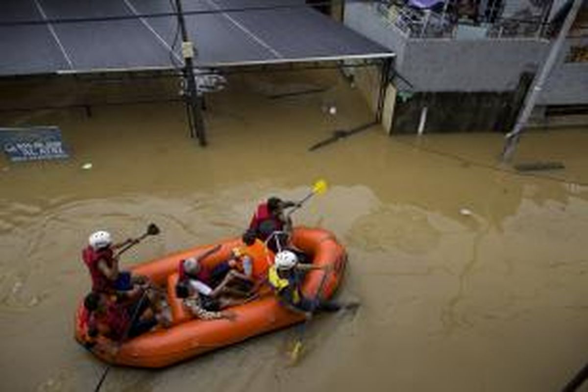Relawan mengevakuasi warga di Kelurahan Kebon Baru, Tebet, Jakarta Selatan, Senin (13/1/2014). Luapan Kali Ciliwung mulai menggenangi permukiman dan memutus Jalan KH Abdullah Syafi'ie sejak Senin dini hari. KOMPAS/AGUS SUSANTO