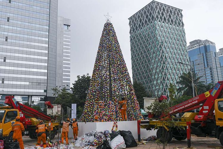 Petugas PPSU menata pohon Natal dari miniatur ondel-ondel yang terbuat dari botol minuman bekas di Food Court Thamrin 10, kawasan Thamrin, Jakarta, Sabtu (21/12/2019). Pemprov DKI Jakarta bekerja sama dengan Keuskupan Agung Jakarta, membangun pohon natal setinggi 11 meter menggunakan 8.000 botol minuman bekas.