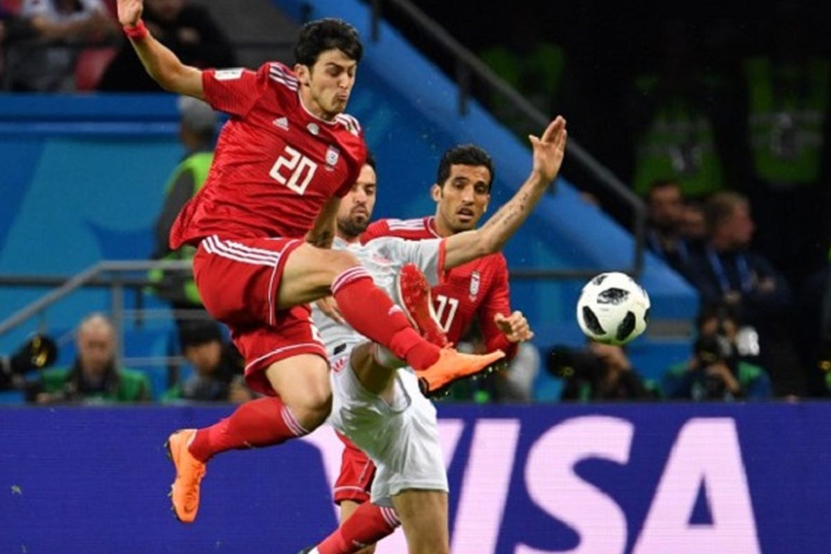 Sardar Azmoun bergerak lebih cepat daripada Sergio Busquets  dalam menyongsong bola pada pertandingan Iran vs Spanyol di Kazan Arena, 20 Juni 2018. 