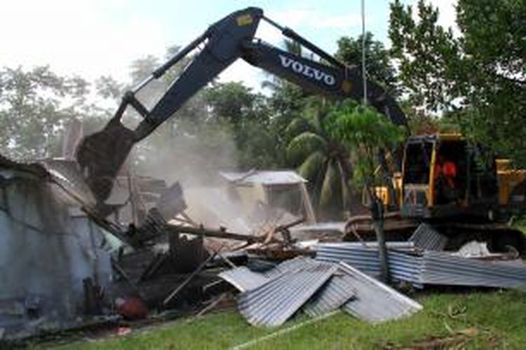 Sebuah alat berat sedang meratakan bangunan rumah tinggal dalam eksekusi yang dilaksanakan Pengadilan Negeri Manado.