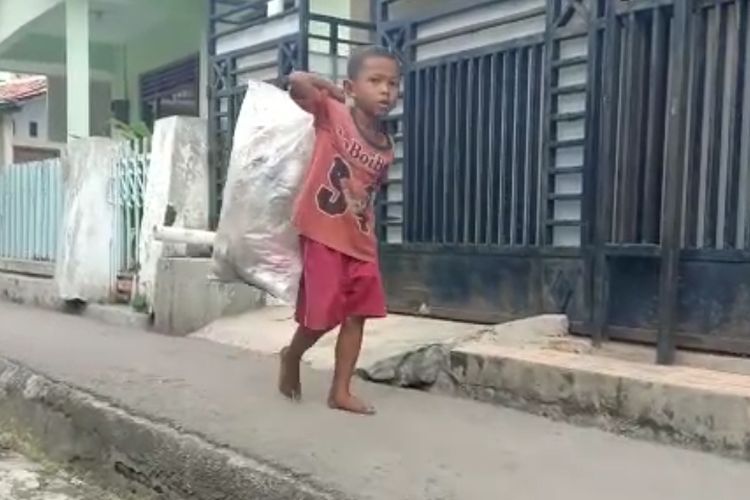 Dengan membawa karung, Ainu Rofiq (8) bocah pemulung di Brebes menyusuri jalanan kampung untuk mencari barang bekas yang hasilnya dijual untuk makan, Kamis (6/1/2022) (Istimewa)