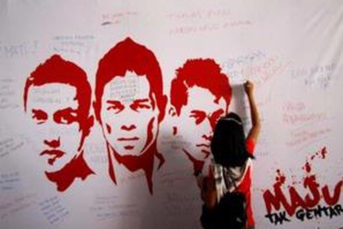 Seorang suporter membubuhkan tandatangan di poster anggota timnas Indonesia sebagai dukungan. Indonesia akan menghadapi Thailand di semifinal Piala AFF.
