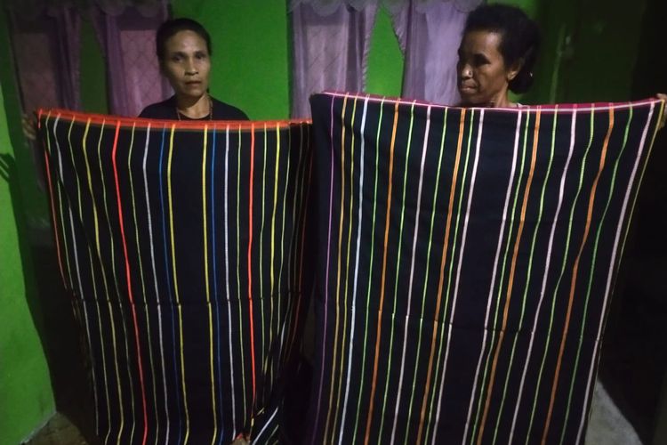 Dari kiri ke kanan, Petronela Evi (46) dan Regina Inus (56) sedang memegang kain tenun puncatiti hasil karya tangan mereka di kampung Wangkar, Desa Ranamese, Kecamatan Congkar, Kabupaten Manggarai Timur, Nusa Tenggara Timur, Sabtu, (11/3/2023).