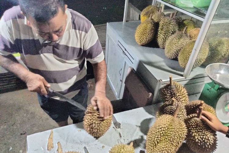 Pedagang durian montong di Desa Kandang, Kecamatan Muara Dua, Kota Lhokseumawe, Provinsi Aceh, Sabtu (19/12/2022) malam. Durian ini dibandrol Rp 50.000 per kilogram lengkap dengan kulitnya.