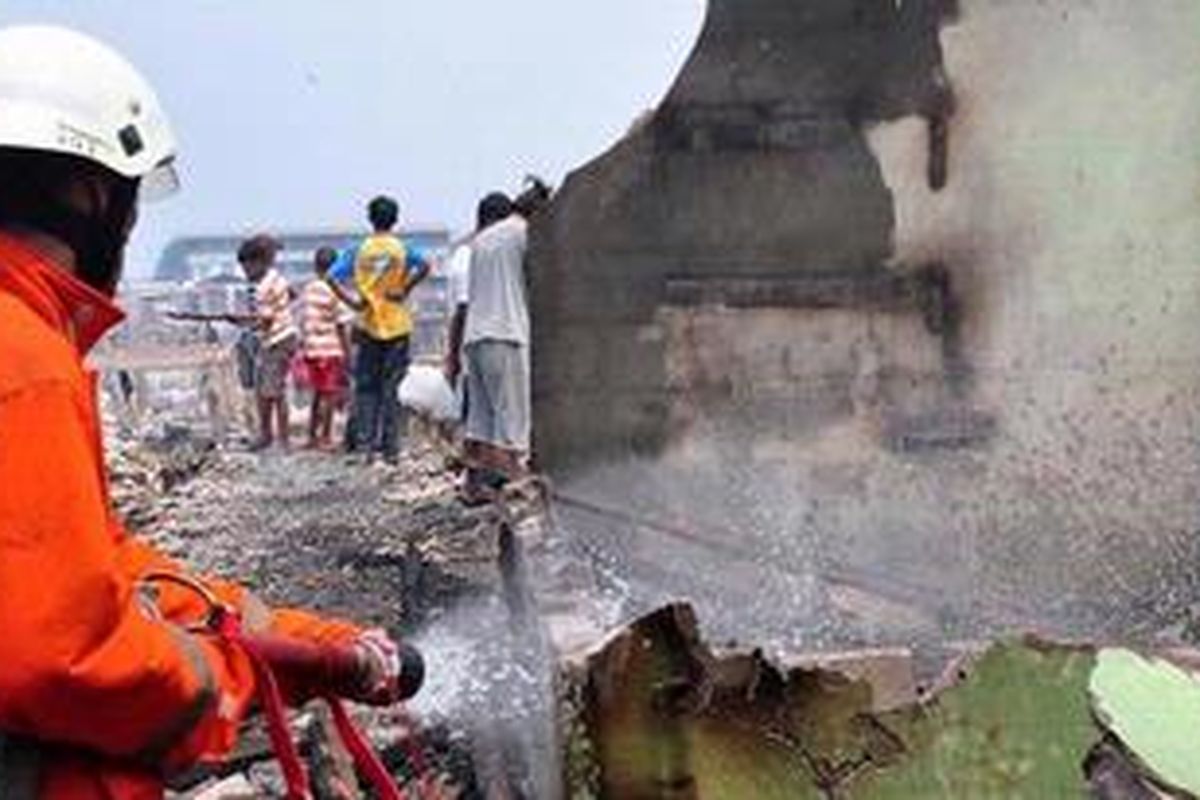 Petugas pemadam kebakaran sedang melakukan upaya pendinginan setelah kebakaran di RT 10 / RW 04, Kapuk Muara, Penjaringan, Jakarta Utara, Rabu (22/8/2012). Kebakaran yang melanda pemukiman padat penduduk tersebut diduga dari sebuah kompor pada pukul 09.30 WIB dan menghanguskan 300-an rumah semipermanen.