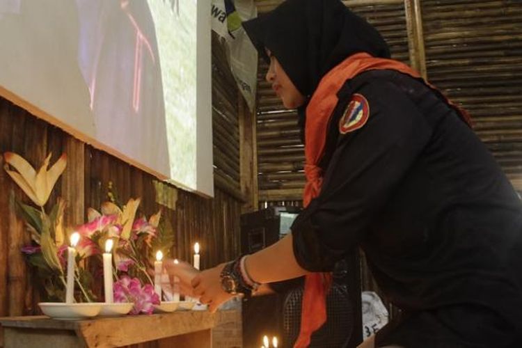 Salah seorang anggota Mapala di Kota Pekalongan menaruh bunga dan lilin dibawah foto korban meninggal setelah melakukan diksar Mapala UII Yogyakarta.
