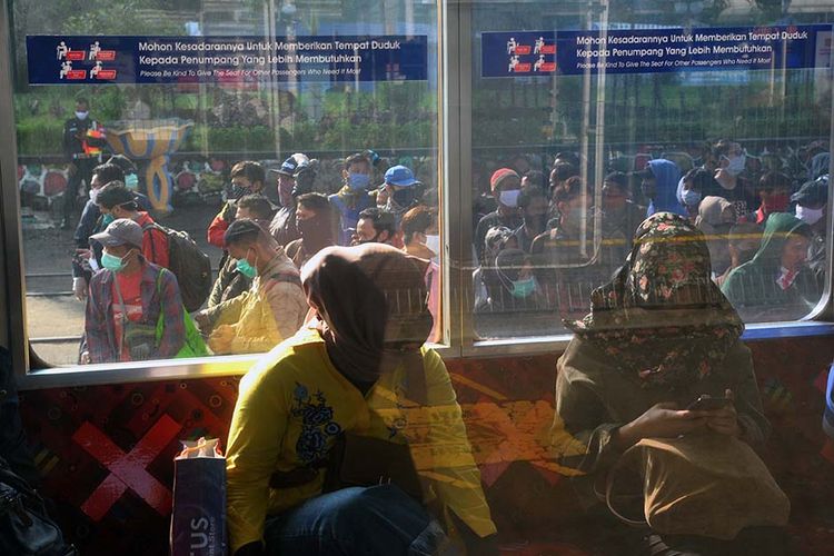 Sejumlah penumpang KRL Commuter Line antre menunggu kedatangan kereta di Stasiun Bogor, Jawa Barat, Senin (13/4/2020). Antrean panjang penumpang KRL Commuter Line di Stasiun Bogor tersebut akibat kebijakan pemeriksaan suhu tubuh dan pembatasan jumlah penumpang di setiap rangkaian kereta sebagai tindakan pencegahan penyebaran wabah pandemi virus Corona (COVID-19).