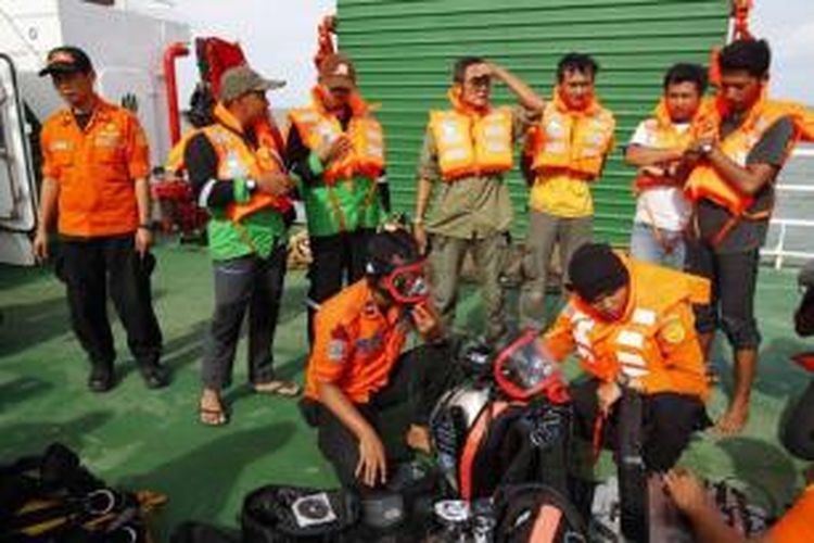 Tim penyelam dari Basarnas menyiapkan perlengkapan selam di atas kapal KN SAR 101 Purworejo, di tengah perairan Pangkalan Bun, Kalimantan Tengah, Jumat (2/1/2015). Pencarian kembali mengalami kendala akibat ketinggian ombak mencapai hingga lima meter.