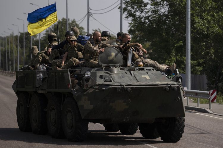 Prajurit Ukraina naik di atas kendaraan lapis baja di jalan di wilayah Donetsk, Ukraina timur, Minggu, 28 Agustus 2022.