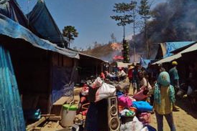 Satu keluarga penambang bersama seorang bocah meninggalkan kawasan tambang Gunung Botak Minggu (15/11/2015). setelah tenda tempat tinggal mereka di kawasan itu dibakar aparat