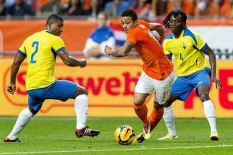 Pemain Belanda, Memphis Depay (tengah) saat berusaha keluar dari kawalan pemain Ekuador, Jorge Guagua (kiri) dan Juan Paredes (kanan) pada laga uji coba di Stadion Amsterdam Arena, Sabtu atau Minggu (18/5/2014) dini hari WIB. Kedua tim bermain imbang 1-1 pada pertandingan tersebut. 