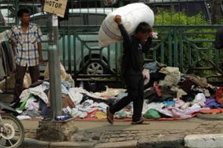 Pedagang Pasar Senen menggelar dagangannya di pinggir jalan Pasar Senen, Jakarta, Selasa (29/4/2014). Mereka terpaksa menjual murah sisa barang dagangan yang berhasil diselamatkan dari kebakaran yang melahap kios mereka.