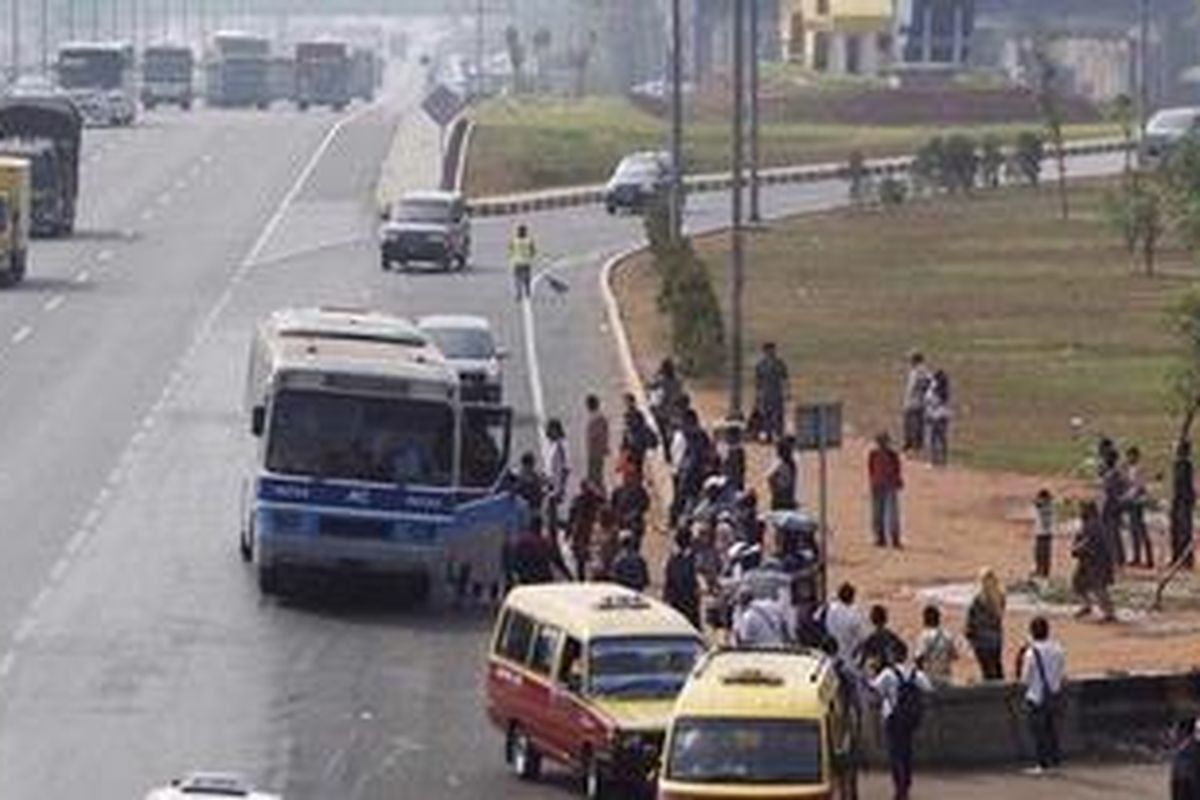 Penumpang turun dan menunggu bus di terminal bayangan (ilegal) di ruas Tol Jatibening Kilometer 8, Pondok Gede, Kota Bekasi, Senin (9/7/2012). Meski sudah ada penertiban dan larangan menaikturunkan penumpang oleh PT Jasa Marga (Persero), pengelola jalan Tol Jakarta-Cikampek namun tiap hari kejadian berulang. Penghitungan Jasa Marga mulai pukul 06.00 hingga 14.00 sebanyak 936 kendaraan menaikturunkan penumpang di lokasi tersebut. 