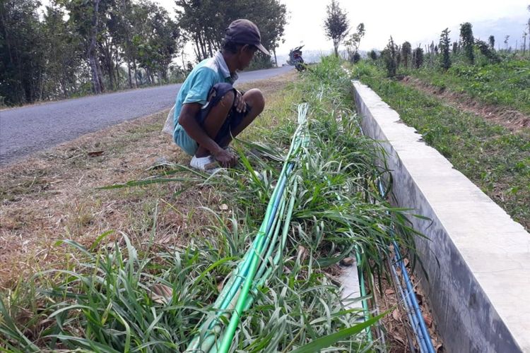 Warga Mengecek Selang Yang Menyalurkan air Ke Rumah Warga di Dusun Selopamioro, Kecamatan Imogiri, Bantul