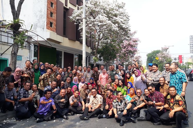Wali Kota Surabaya beserta jajaran forkopimda, kepala OPD, dan para penerima beasiswa penerbangan foto bersama dengan latar bunga tabebuya di Jalan Mayjend Sungkono, Surabaya, Jawa Timur, Rabu (20/11/2019).